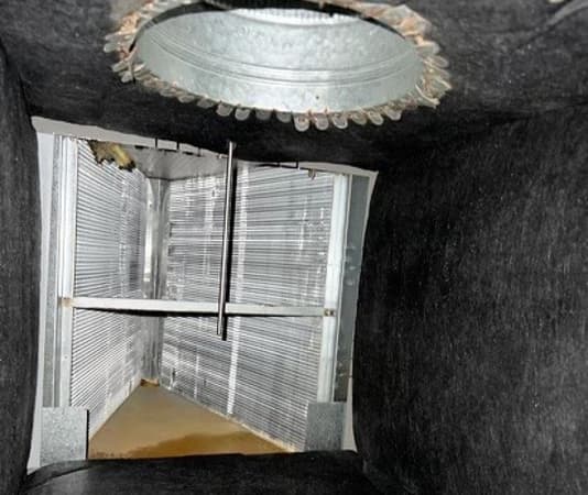 Serpentín evaporador al que se accede mediante una abertura cortada en el plenum
