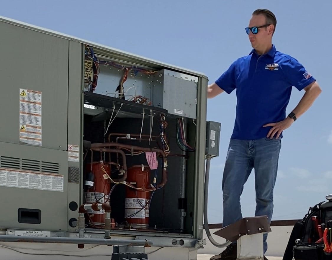 An Air Star Now technician working an open rooftop package unit