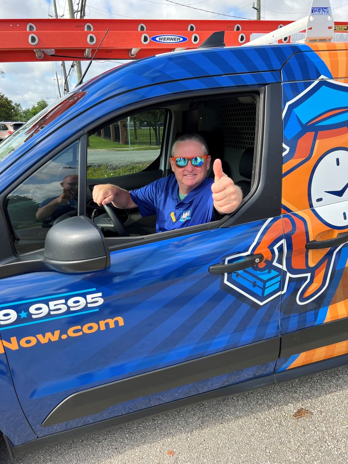 An Air Star Now technician giving a thumbs up from a branded service van